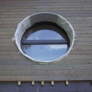 fenêtre ronde dans une maison en bois