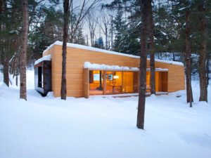 maison bois en forme d'une luge dans la forêt canadienne