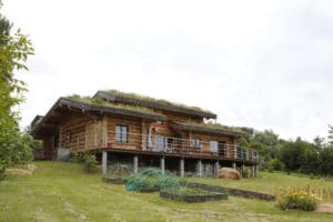 grande maison bois sur une petite colline
