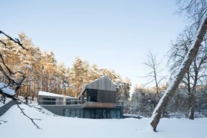maison bois enneigée en lituanie