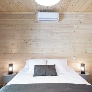 Une chambre parentale tout en bois dans une maison bois à Moliets-et-Maa