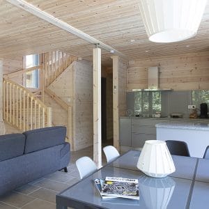Séjour avec escaliers en bois dans une maison bois familiale