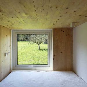 chambre à coucher avec fenêtre d'une maison bois