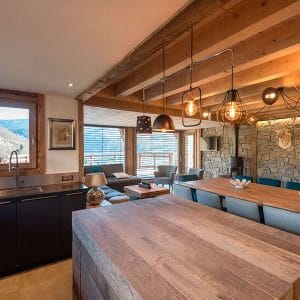 Une salle à manger et un séjour qui mêlent bois et pierre