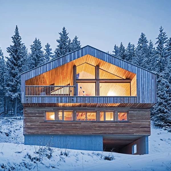 chalet en bois design niché dans la fôret enneigée