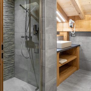 Une salle de bains grise et bois dans un chalet bois dans les Vosges