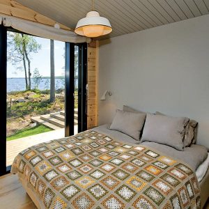 chambre des parents avec grande fenêtre dans petite maison bois
