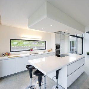 cuisine ouverte blanche dans maison bois moderne avec piscine
