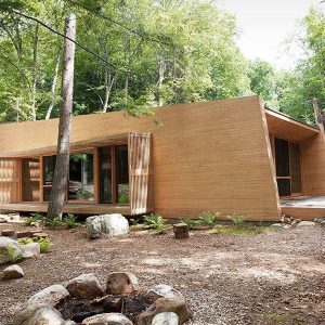 Maison bois au Canada plongée en pleine forêt candienne