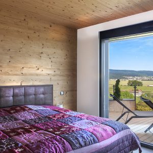 chambre des parents en bois dans maison bois à Dommartin
