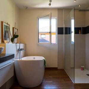 salle de bains au parquet dans maison bois avec piscine