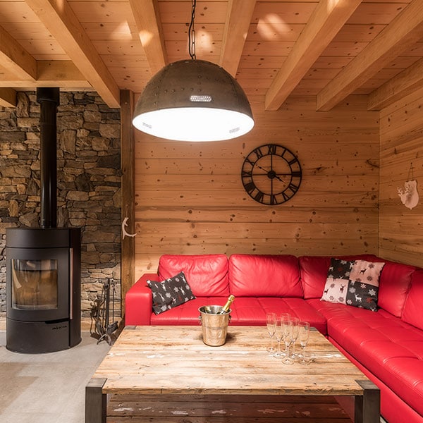 Ce salon tout en bois apparent est chauffé à l'aide d'un poêle à bois