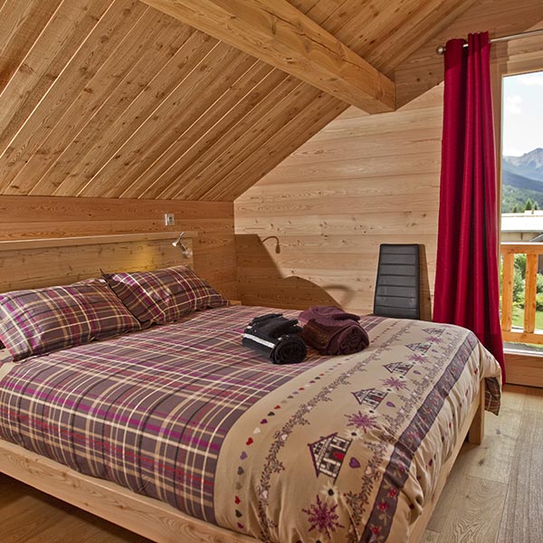 chambre des parents en bois dans maison bois en Hautes-Alpes