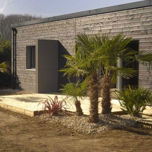 maison bois en cube, vue de l'extérieur avec palmiers