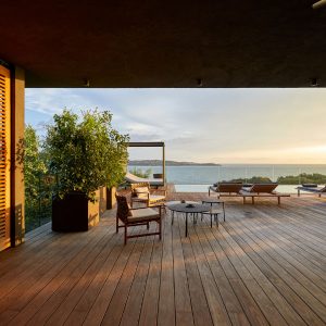 Terrasse en bois naturel avec salon extérieur et piscine