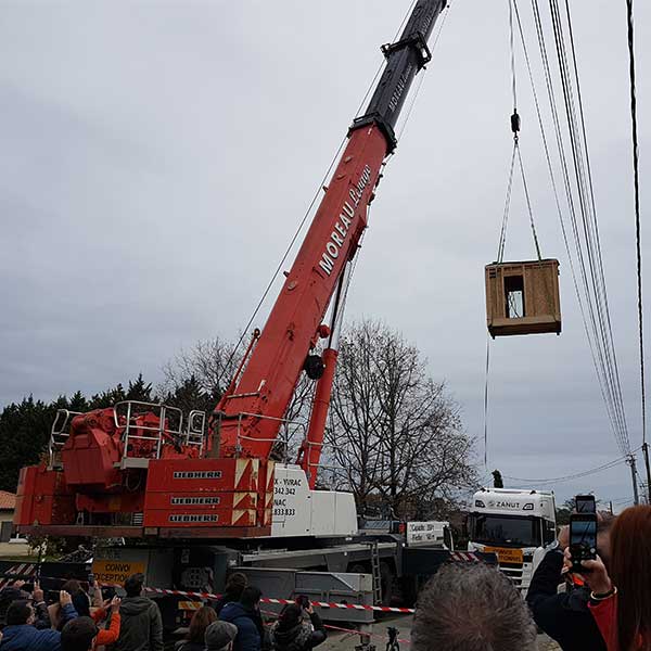 Une grue lève l'un des modules bois de la maison M de l'entreprise Ademeure à Langon  © Claire Thibault